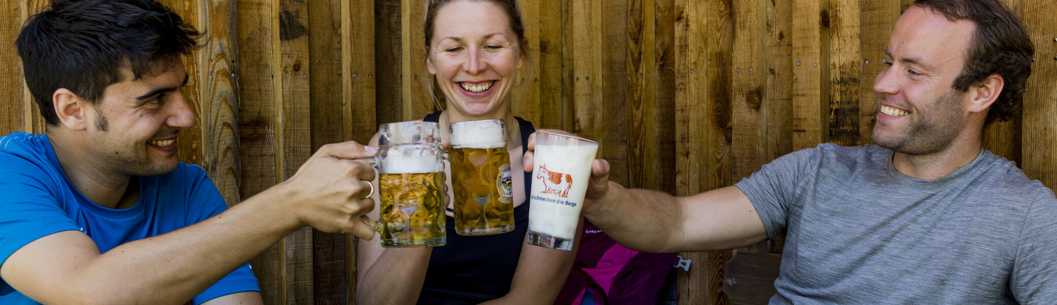 Auf der Hütte: Drei Personen stoßen mit Bierkrügen an | © DAV/Hans Herbig